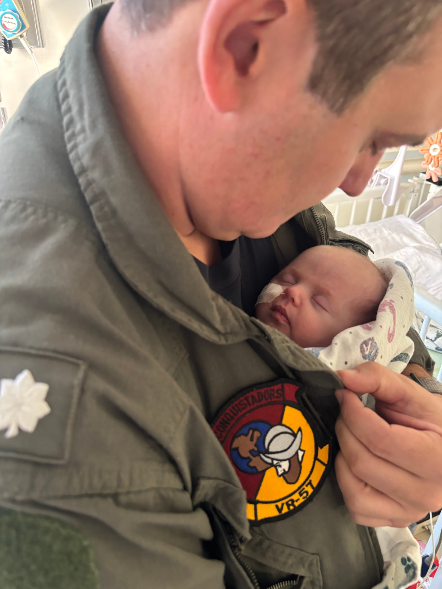 Delaney's father, a U.S. Navy aviator, holding her in the NICU